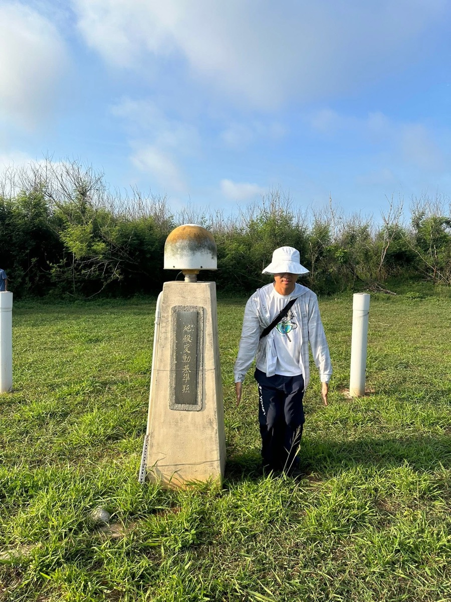 Field geologist beside a seismic monitoring station